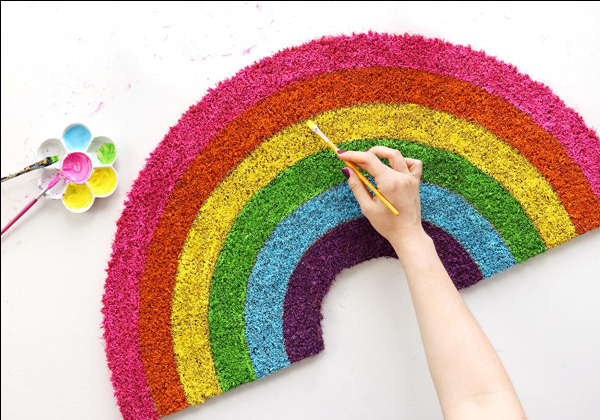 Photo of a person painting a rainbow doormat